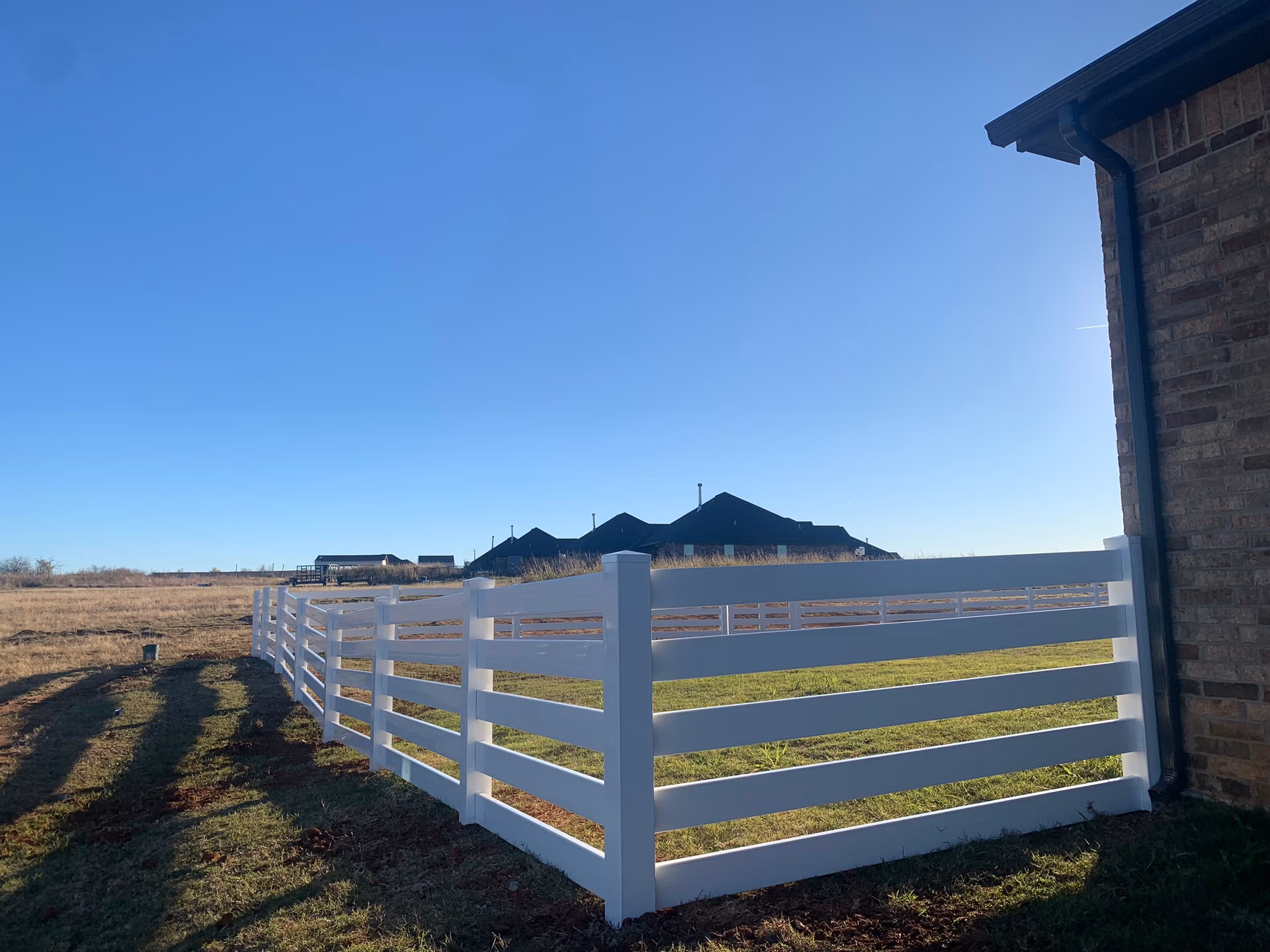 White vinyl fence installation by Midland Vinyl Products near McClain County, enhancing property landscaping
