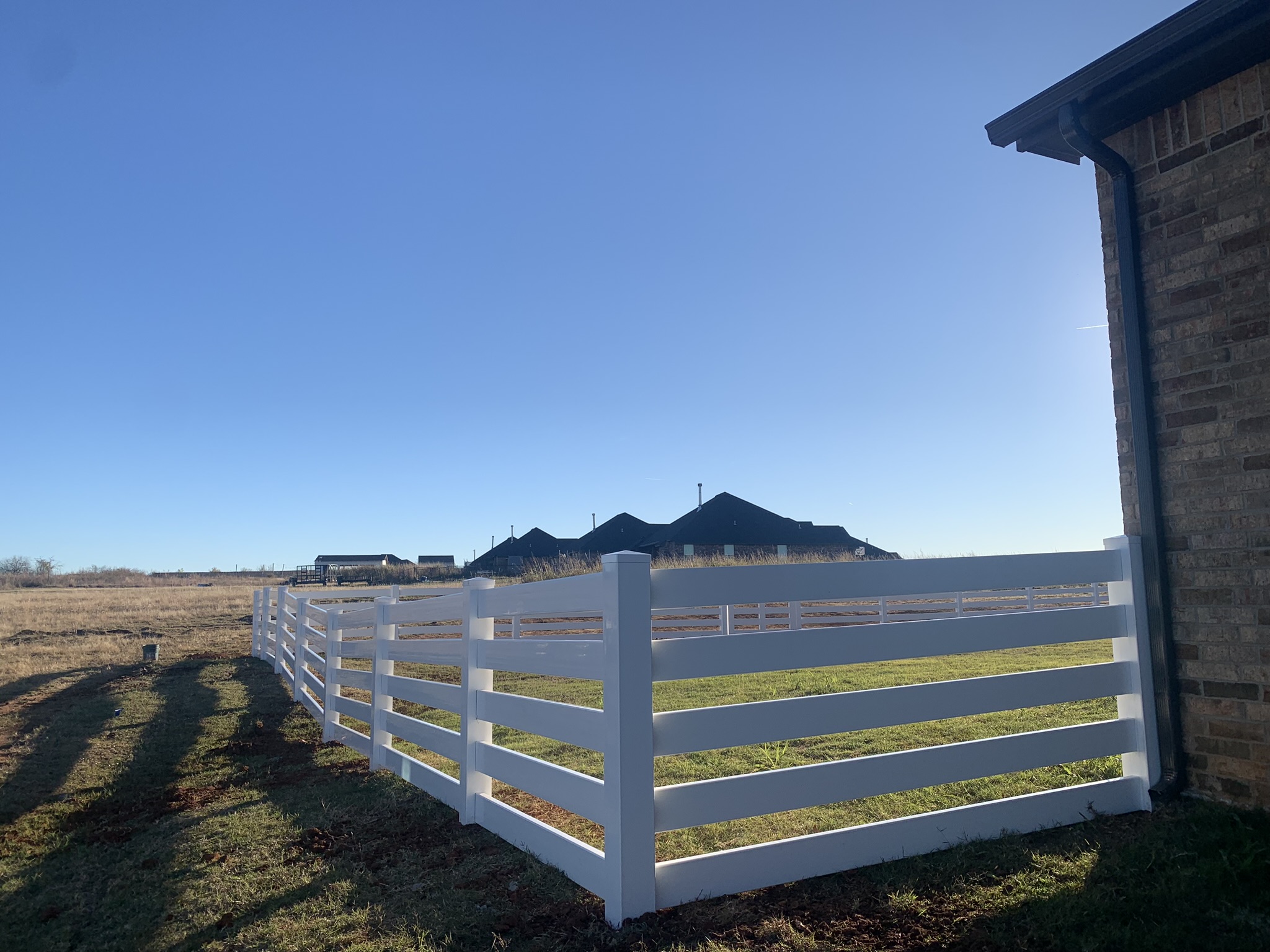 White vinyl fence installation by Midland Vinyl Products near McClain County, enhancing property landscaping